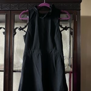 Black Sleeveless romper with ruffle neckline and tie in back. NWOT